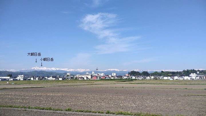 国道112号線から寒河江市内と朝日連峰大朝日岳が見える風景。