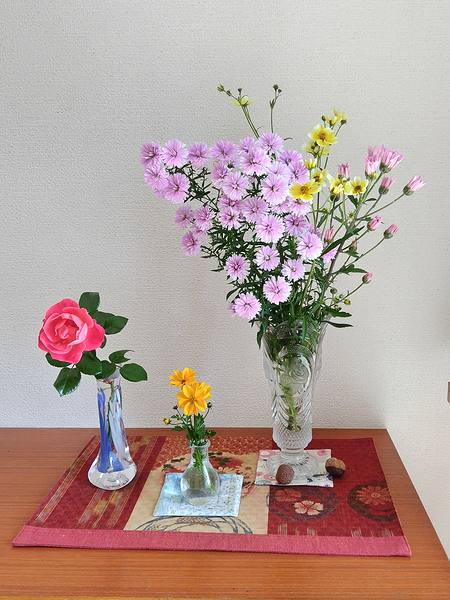 玄関に飾ってある花瓶に入れた花いっぱいの画像。